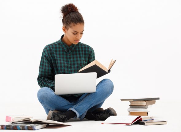 Portrait of young african girl with laptop over white background